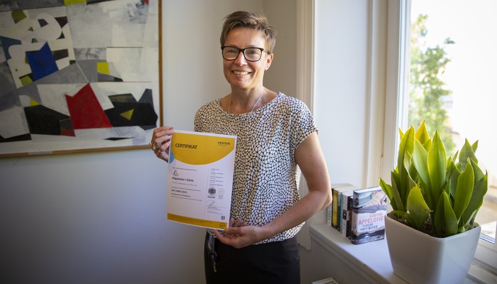 Jenny Riddarström, tf. chef för ledningskansliet. Visar det nya certifikatet Högskolan fått efter miljörevisionen.