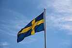 Svenska flaggan svajandes mot blå himmel